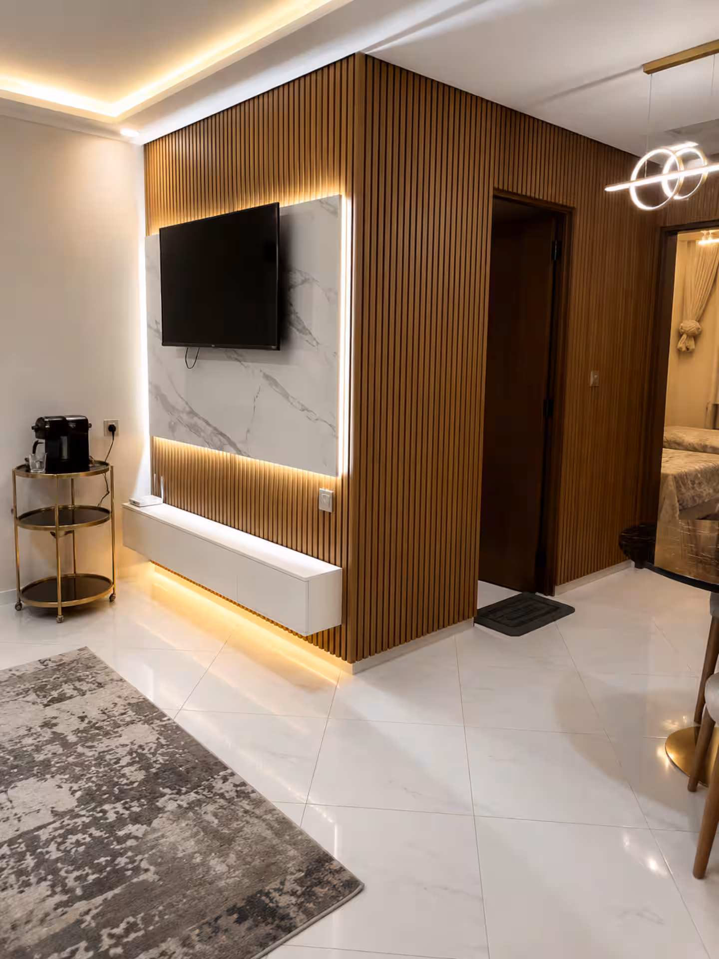 Media wall with marble backsplash and hallway view