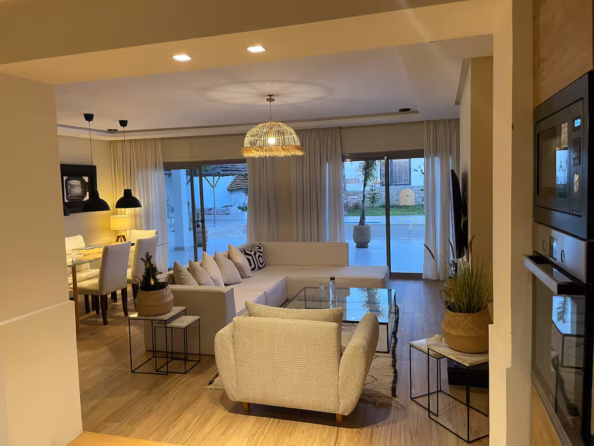 Living room and dining area at a Nūr-managed villa in Tangier, in the evening
