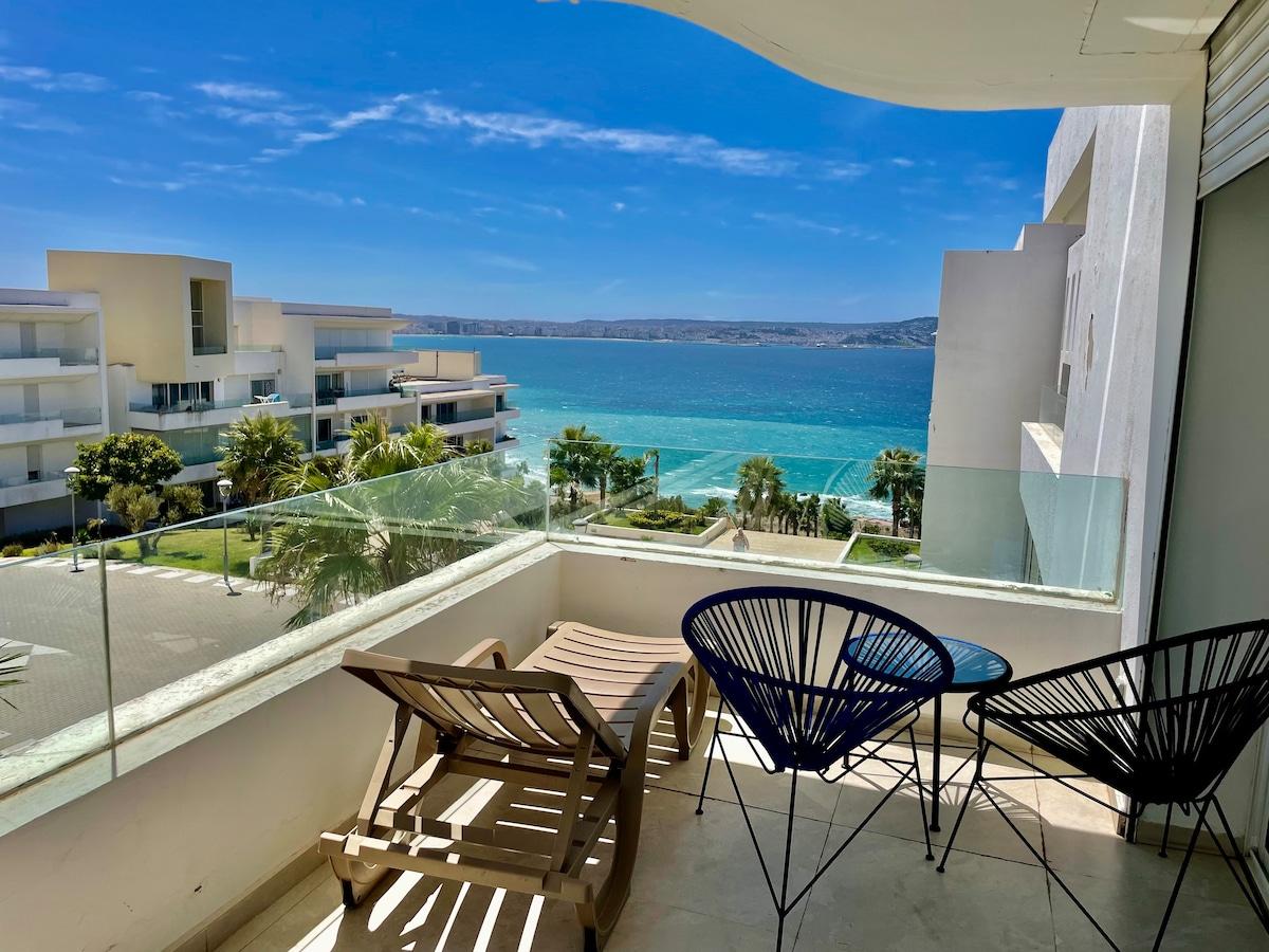 Balcony with sea view, blue sky and outdoor seating